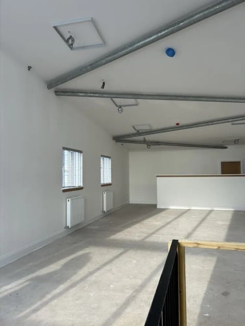 Bare new-build room with exposed ductwork