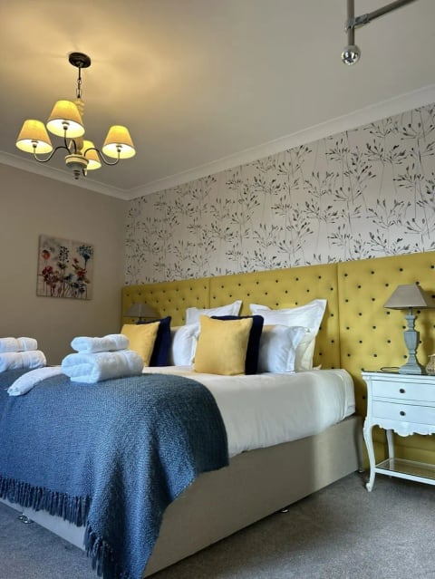 Hawkswood bedroom with a yellow headboard, made up for the next guests